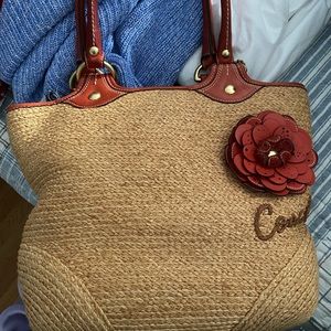 Woven straw Coach purse with leather handles and rose accent